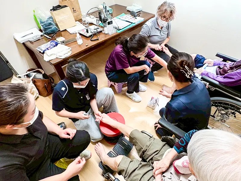 施設で爪ケアの実践練習をしている場面